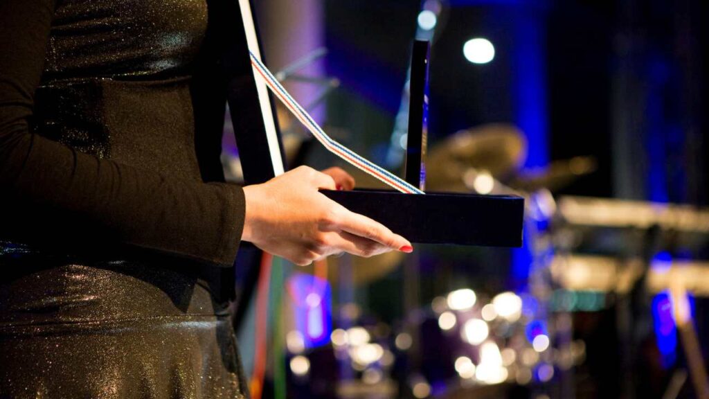 Close up of a woman's hands holding a presentation box with an award