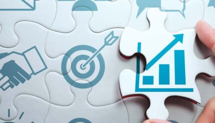 Hand holding a jigsaw puzzle piece with graph for business growth