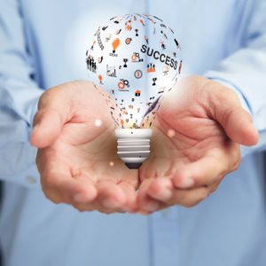 Man holding a stylised lightbulb in the palms of his hands with success on it
